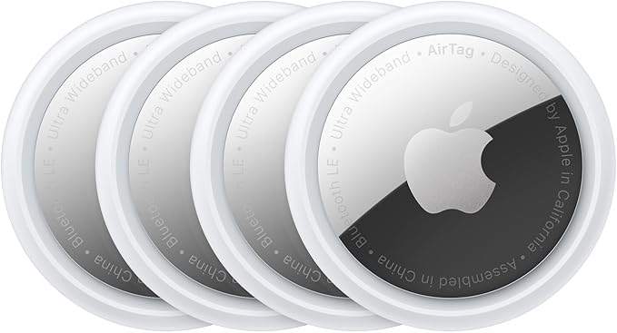 Apple AirTags four-pack shown in a row, small white trackers designed for finding keys, wallets, and bags.