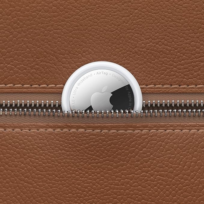 Apple AirTag discreetly placed inside a leather bag pocket for tracking belongings.
